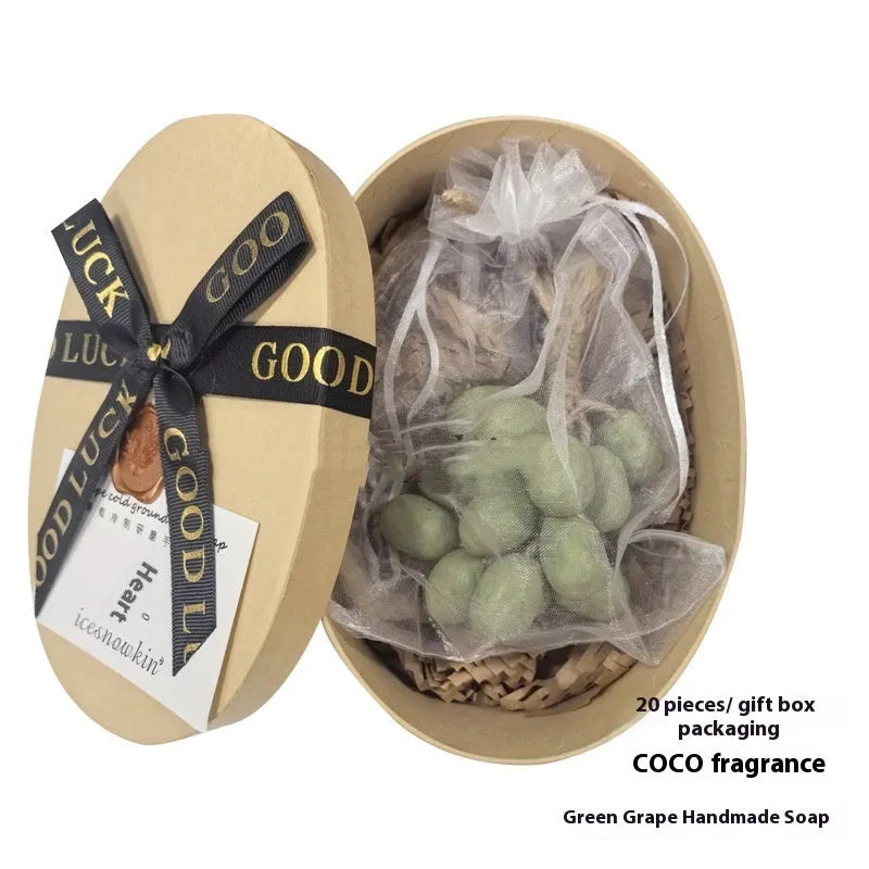 Handmade grape soap bars in black, green, and purple grape scents alongside litchi soap, with gift box and mesh bag packaging