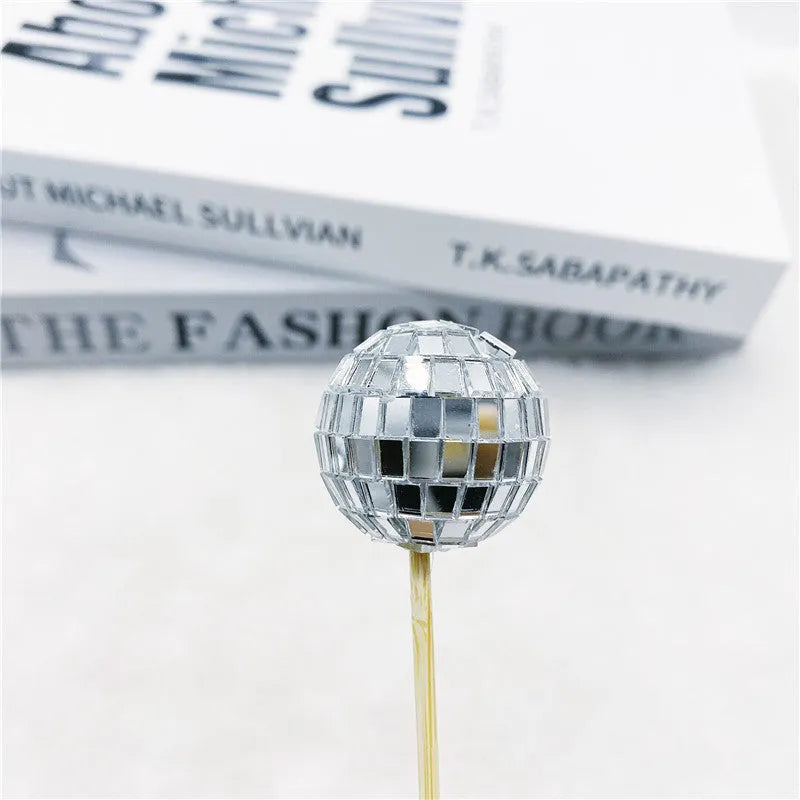 Glass disco ball cake decoration on a wooden stick, shown in different sizes for birthday cakes.