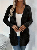 A grey loose fit long sleeve cardigan with pockets hanging on a hanger.