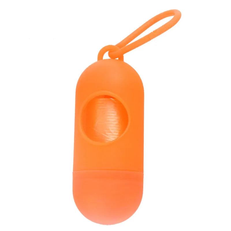 A small black plastic dog poop bag holder with a hook and Velcro strap, shown next to a roll of bags.