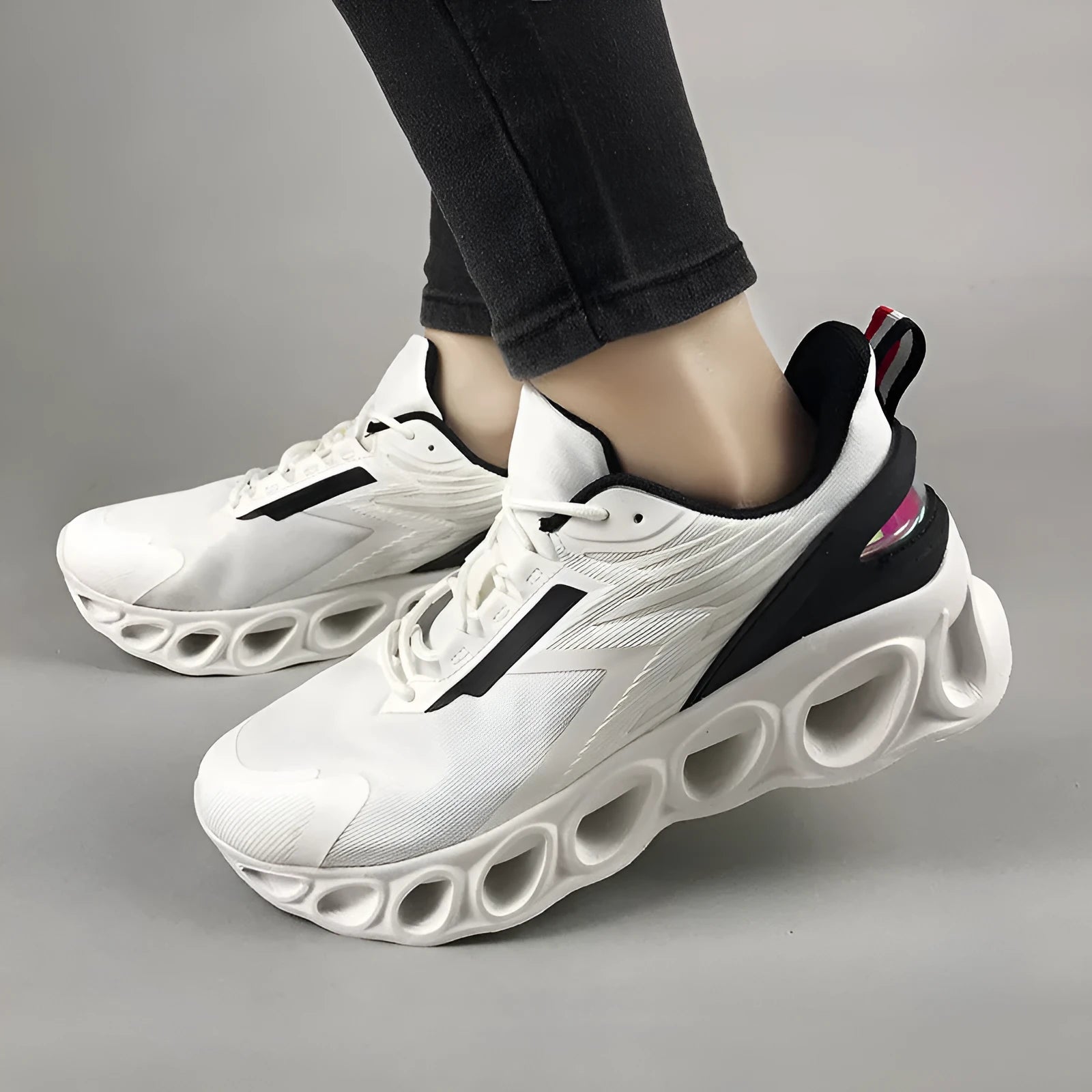 A pair of black low-top casual sports shoes with mesh upper and lace-up front.
