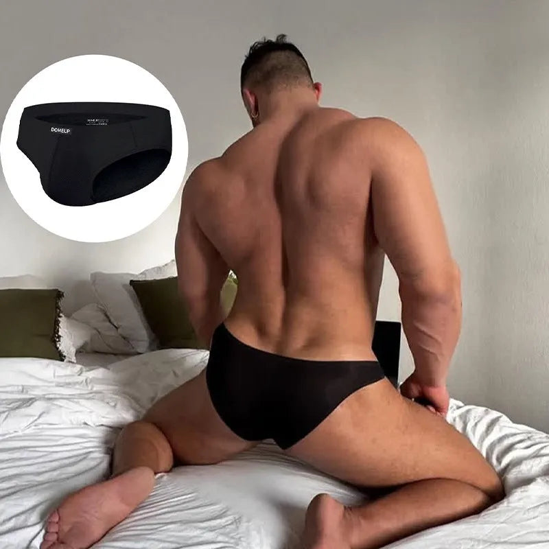 Men's solid colour seamless low-waist briefs in white, black, and pink laid flat.