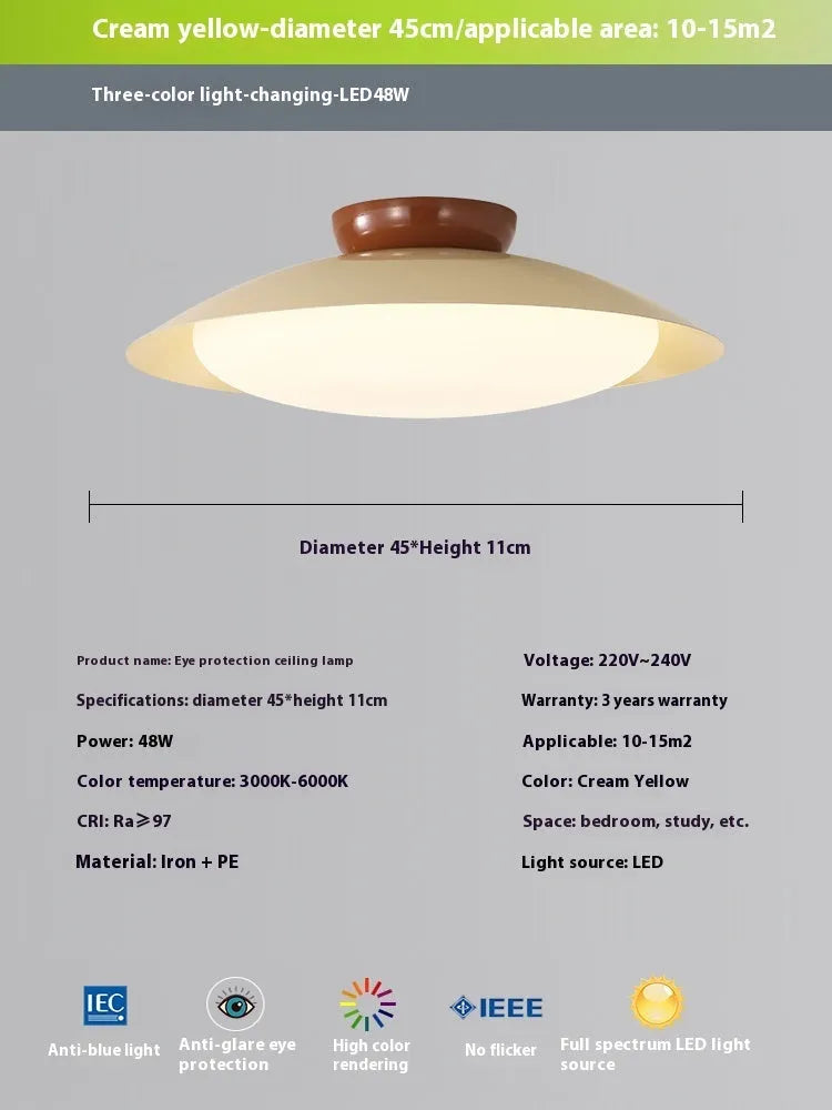Modern flying saucer shaped ceiling lamp with an iron shade, shown in a cream yellow finish.
