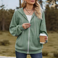 Green women's hooded zipper coat with long sleeves on a hanger