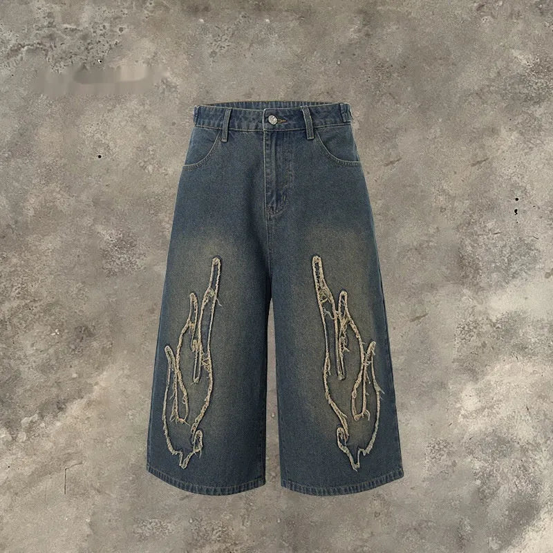 Men's black denim shorts with flame embroidery and cropped patch design on straight-leg cut