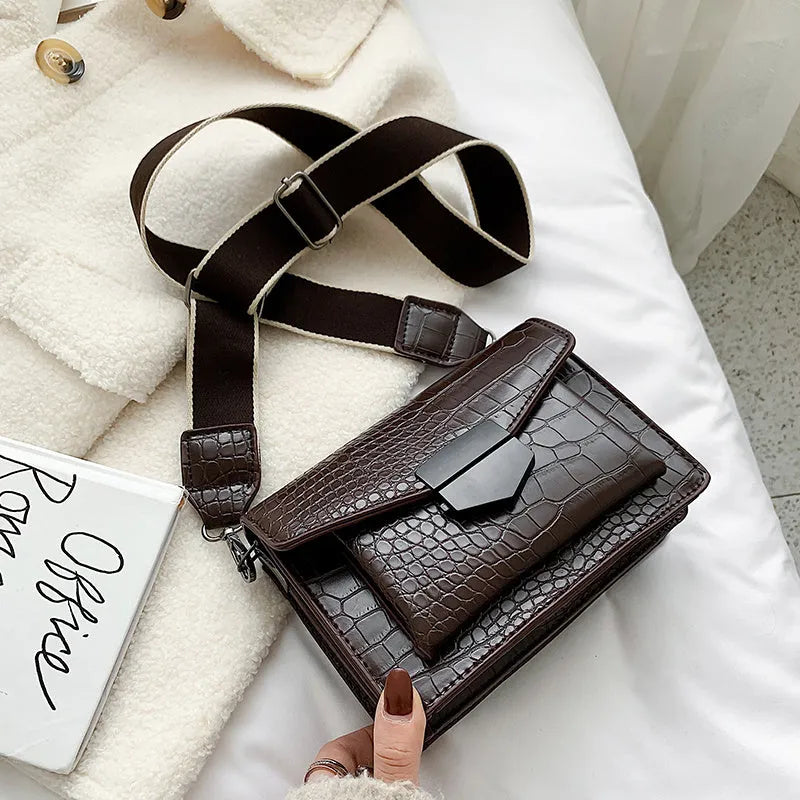 Vintage PU crossbody bag in black, shown with adjustable strap and open to reveal polyester lining.