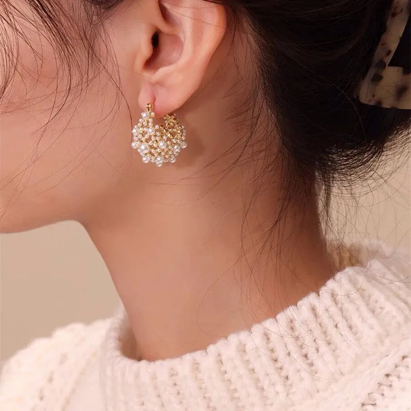 Gold-coloured copper earrings with a small bead flower basket design.