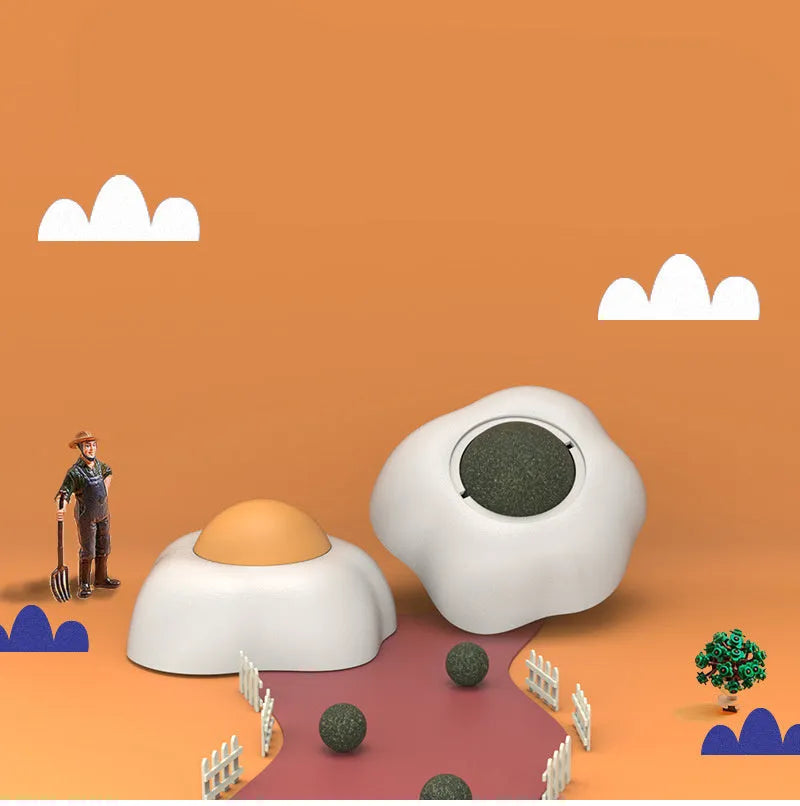Soft plush catnip ball toy with suction cup mounted on a wall, shown in fried egg and poached egg shapes.