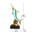 Close-up of a detailed resin European swordfish ornament in bright gold colour on a shelf.