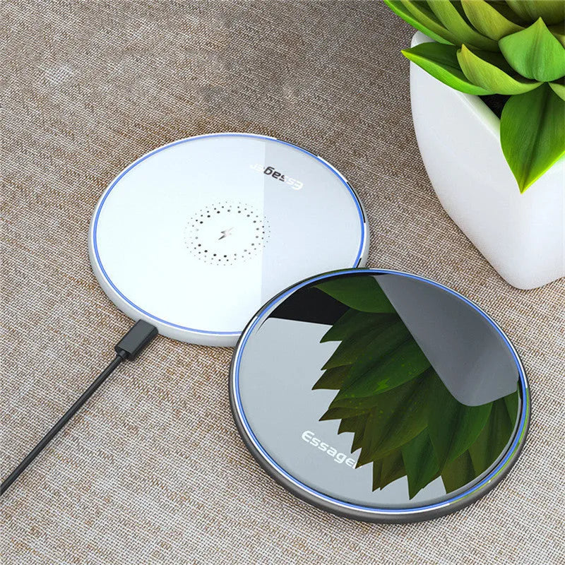 Black 15W fast wireless charging pad with LED indicator light on a desk
