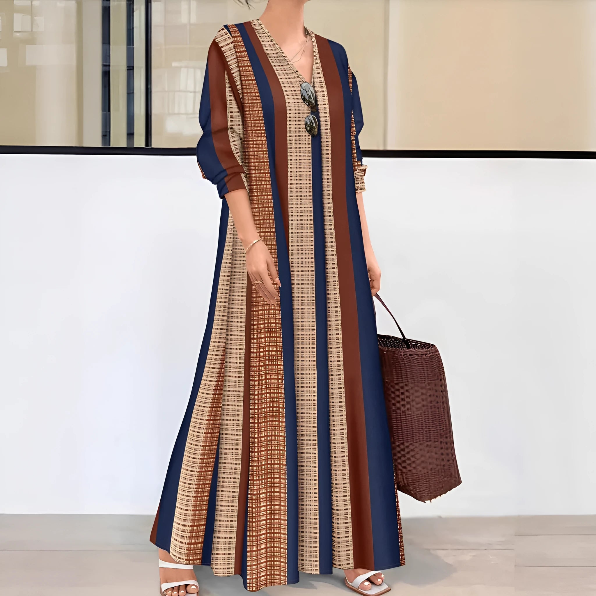 Camel coloured women's long dress with vertical stripes, V-neck, and long sleeves.