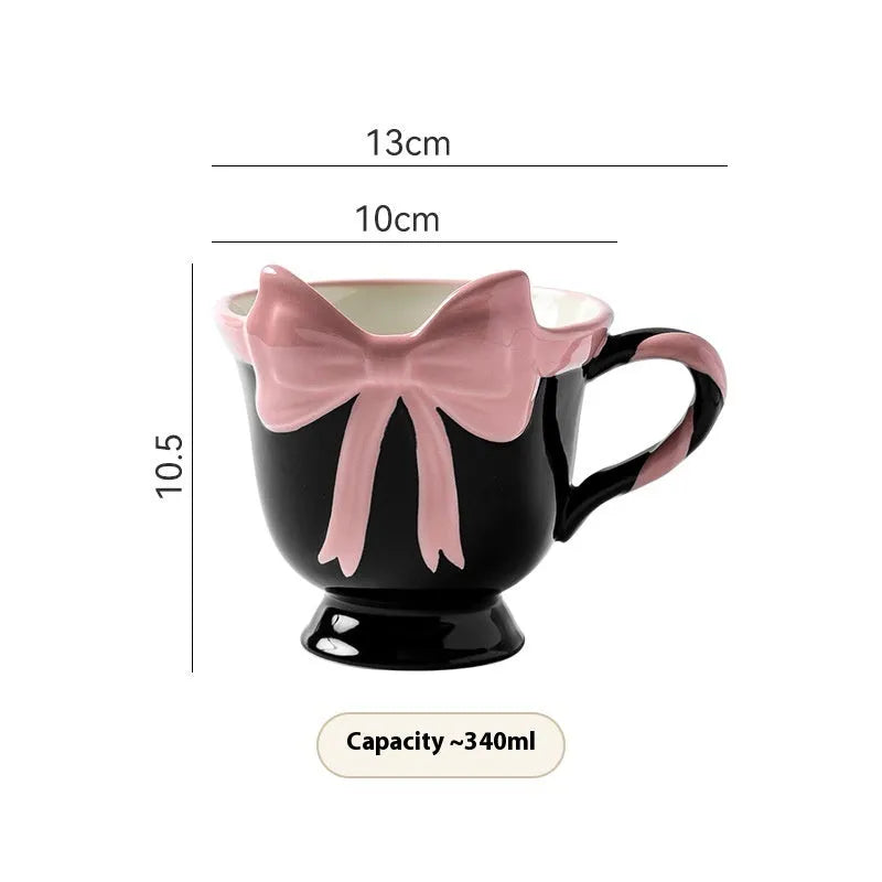 Ceramic mug with a pink and white girl's heart bow decoration on the side.