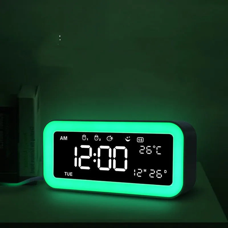 Blue rectangular LED atmosphere light alarm clock with digital display on a desk.
