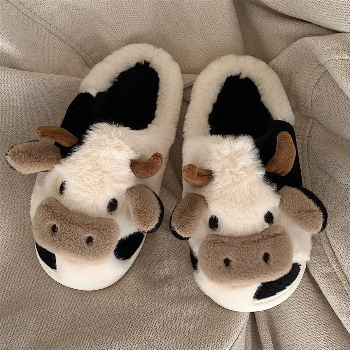 White cow design slippers with plush faux fur upper and textured non-slip sole