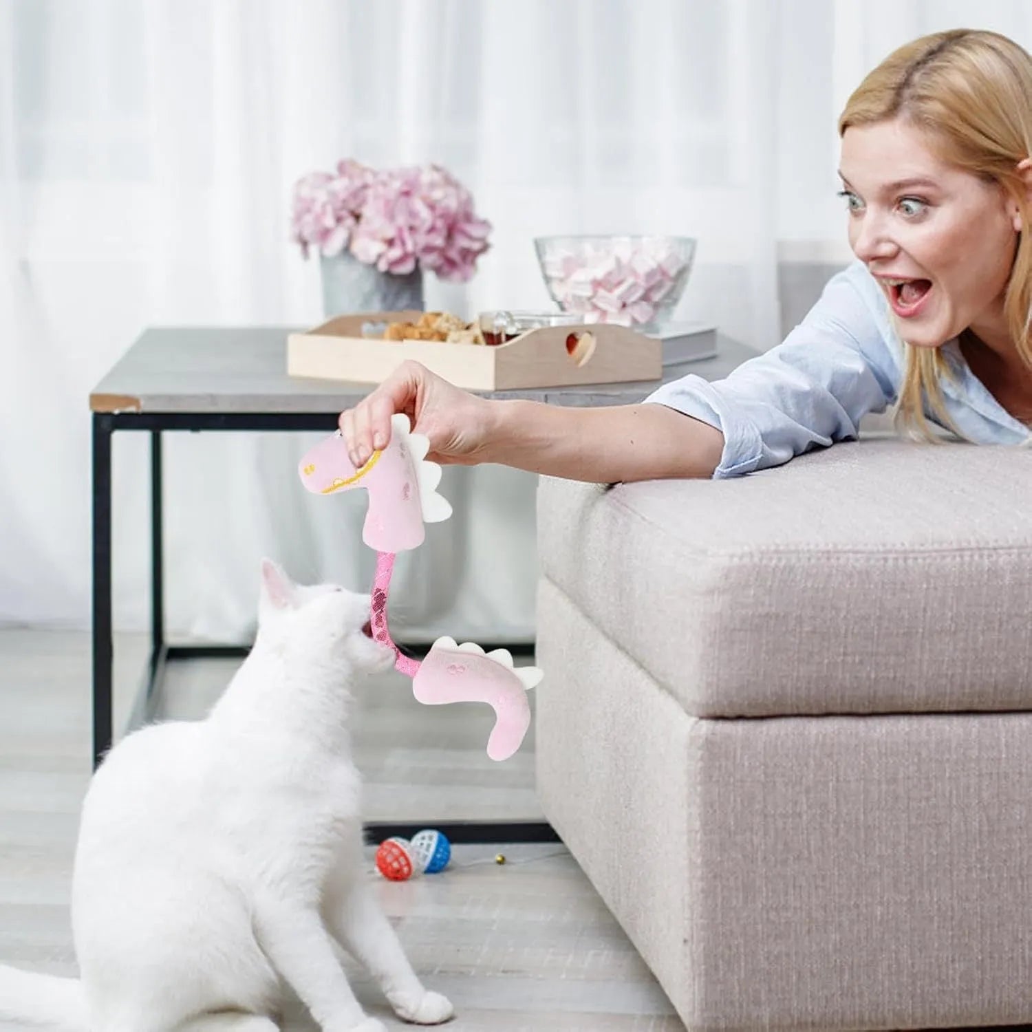 Four different cat chew toys including rope, spring, and plush kicker types in pink, purple, or yellow colours