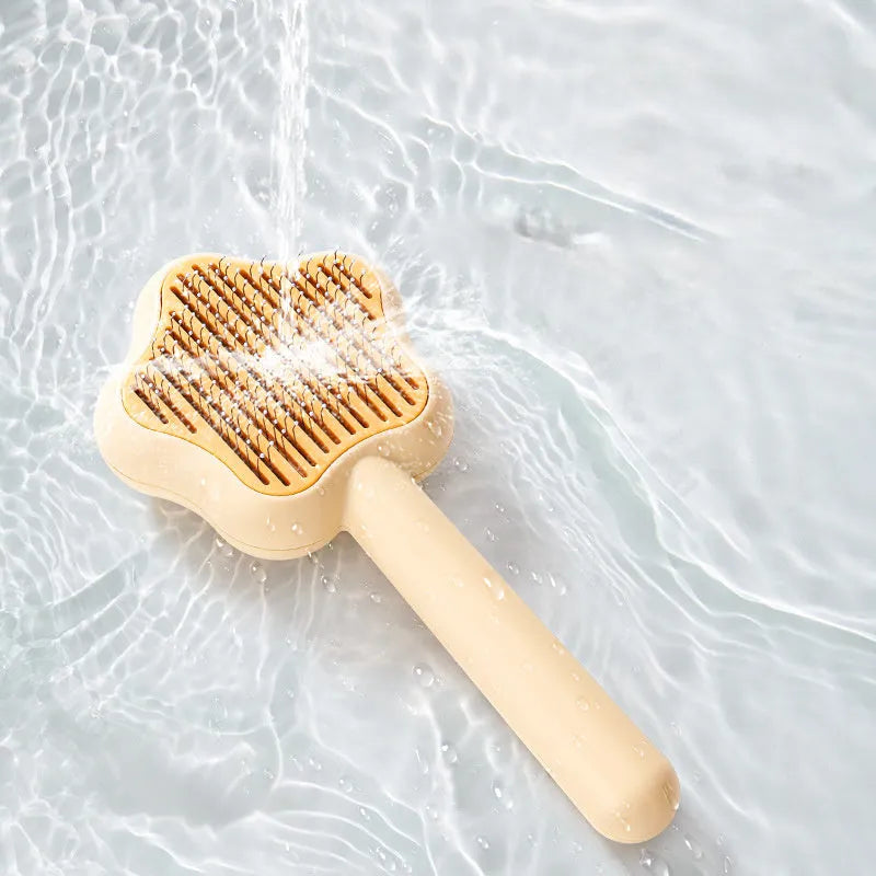 Green stainless steel self-cleaning cat comb with needle bristles on a white background.