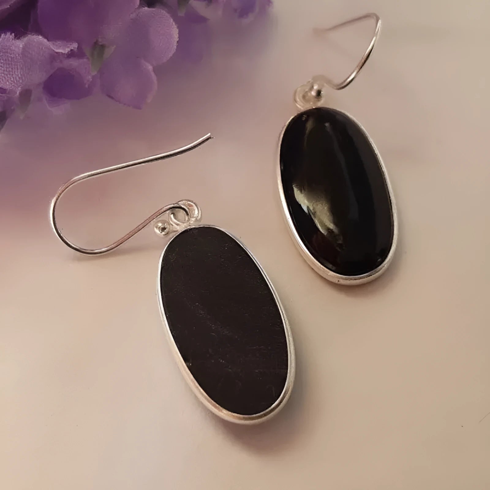 Pair of women's earrings with oval black agate pendant on silver electroplated alloy geometric setting.