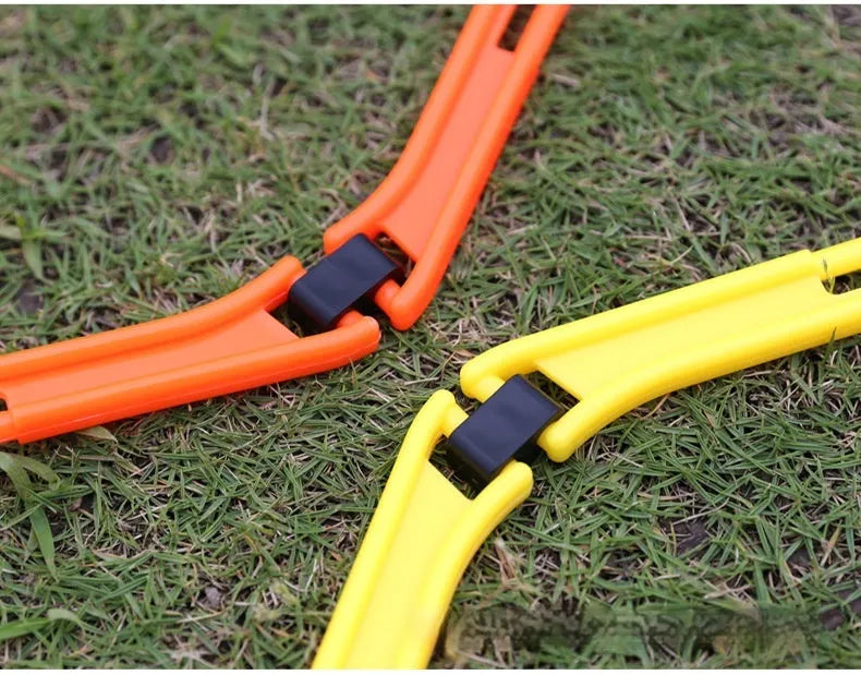 Set of six foldable yellow green and orange hexagon football agility training rings on grass.