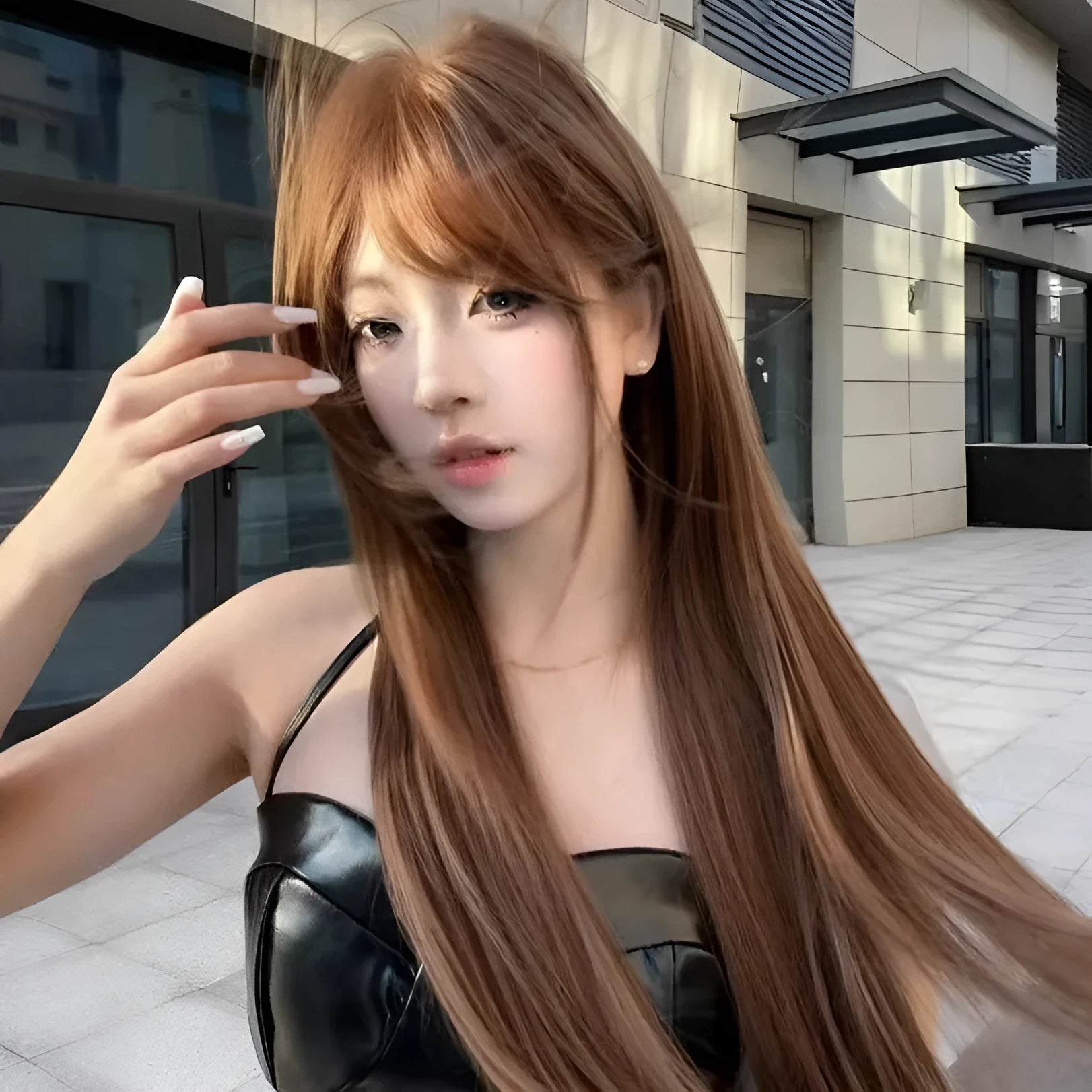 Warm brown long straight synthetic wig with bangs on display stand