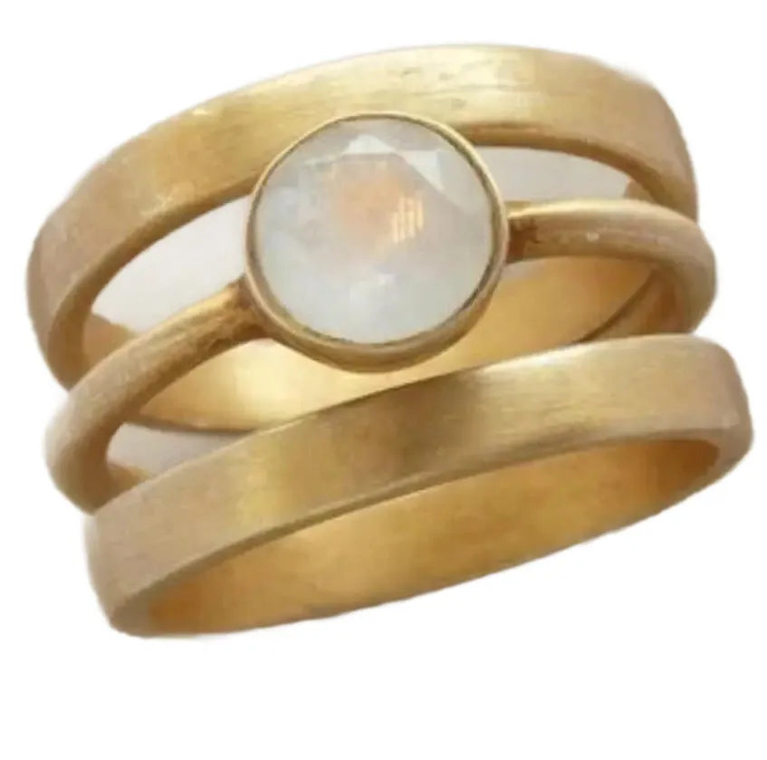 Gold geometric titanium steel ring with micro-inlaid white chalcedony stone on a plain background