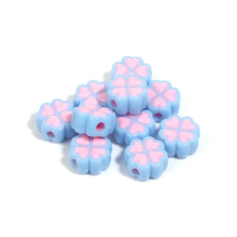 A pile of 15mm frosted acrylic four-leaf clover beads in mixed colours including pink, green, and blue.