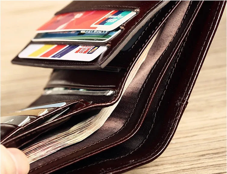Men's black leather wallet open to show internal compartments: photo slot, card slots, banknote folder, and change pocket.
