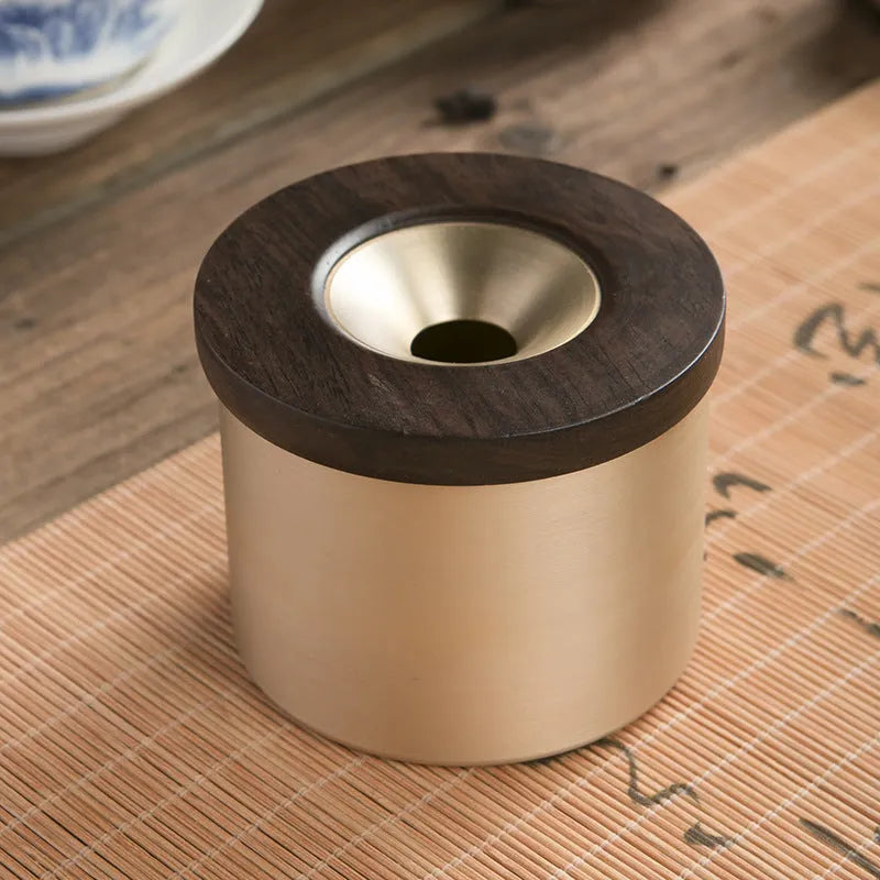 Retro-style brass ashtray with a wooden lid, shown in a home living room setting.