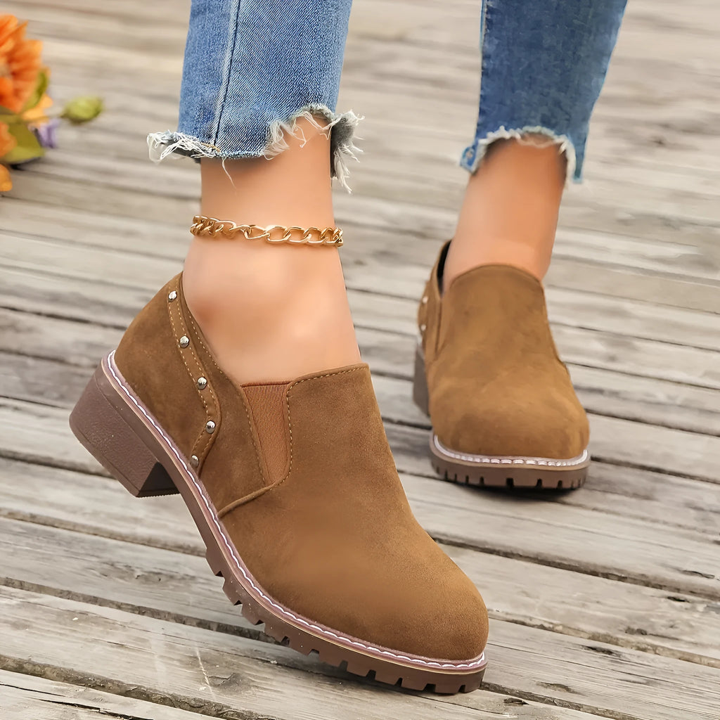 Women's light brown suede ankle boots with a low stout heel and elastic band at the ankle.