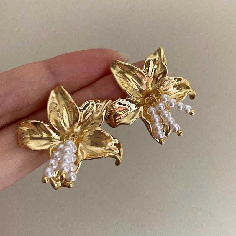 Gold H1795 metal flower earrings with pearls and an exaggerated, personalised design.