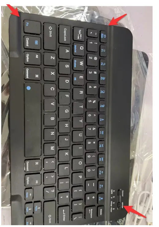 Black mini Bluetooth wireless keyboard next to 10-inch tablet showing wireless connection