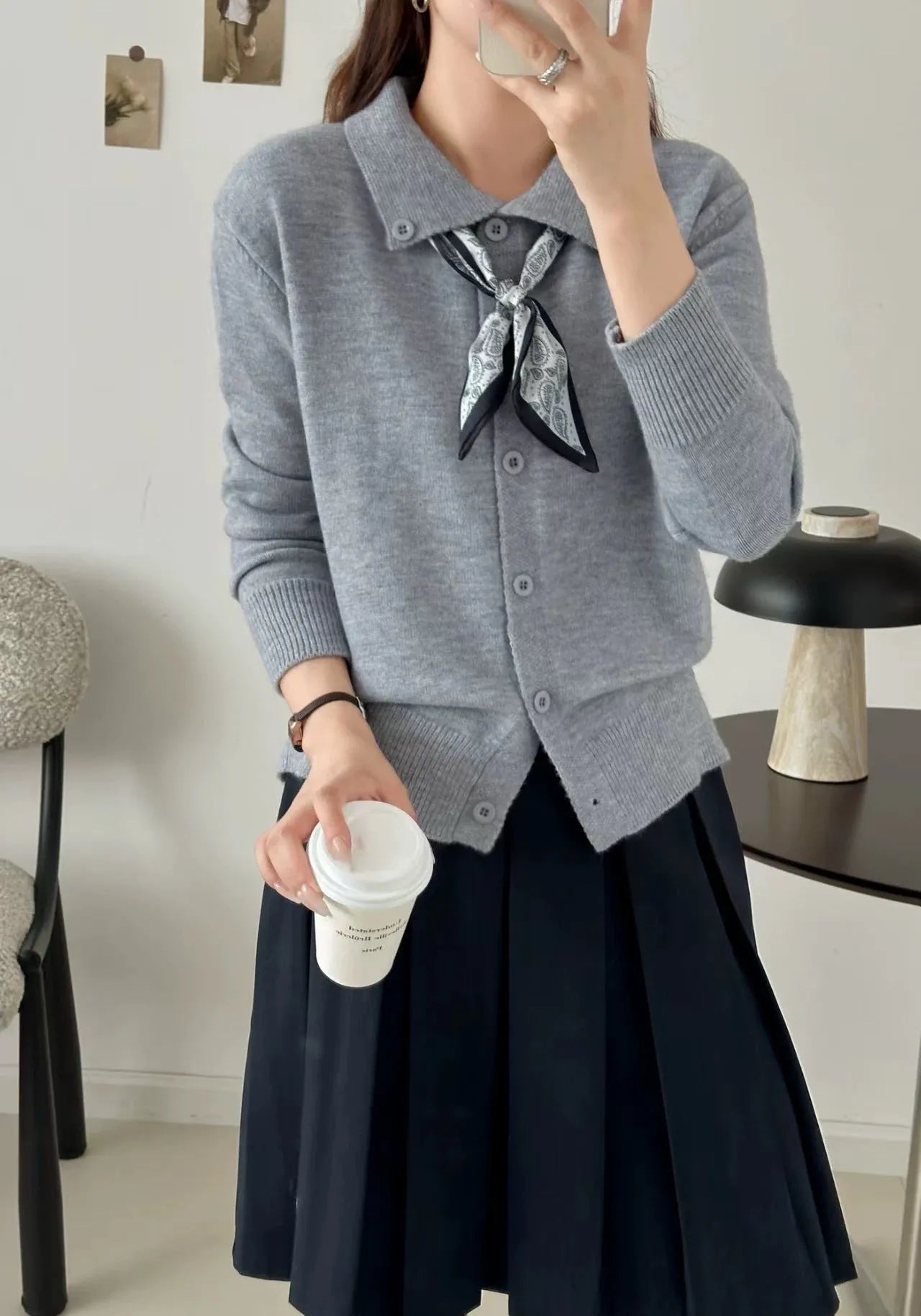 Women's beige lapel scarf collar acrylic cardigan sweater on a hanger.