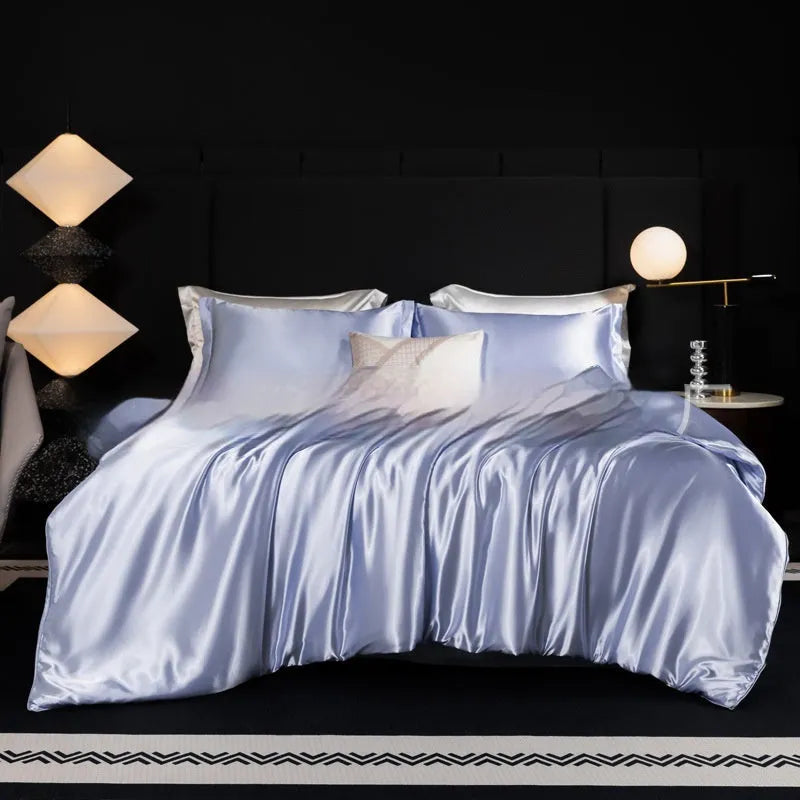 Solid colour silk bedding four-piece set shown in twilight blue on a bed.