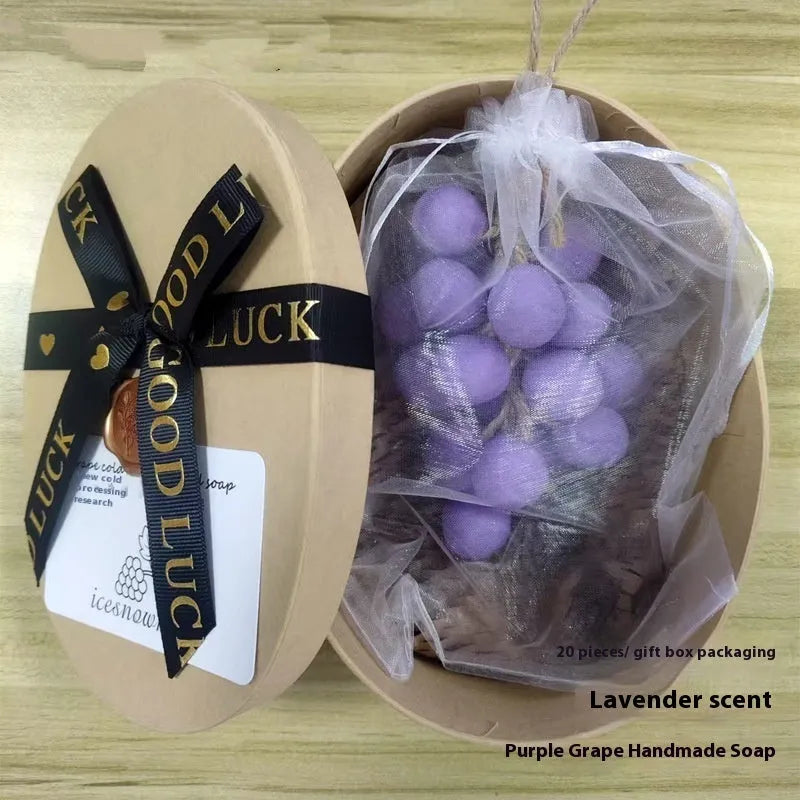 Handmade grape soap bars in black, green, and purple grape scents alongside litchi soap, with gift box and mesh bag packaging