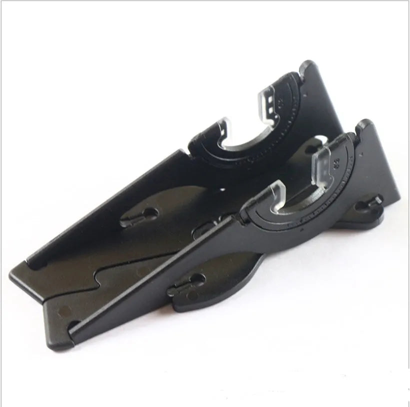 Black plastic card-type mobile phone holder propping a smartphone on a desktop