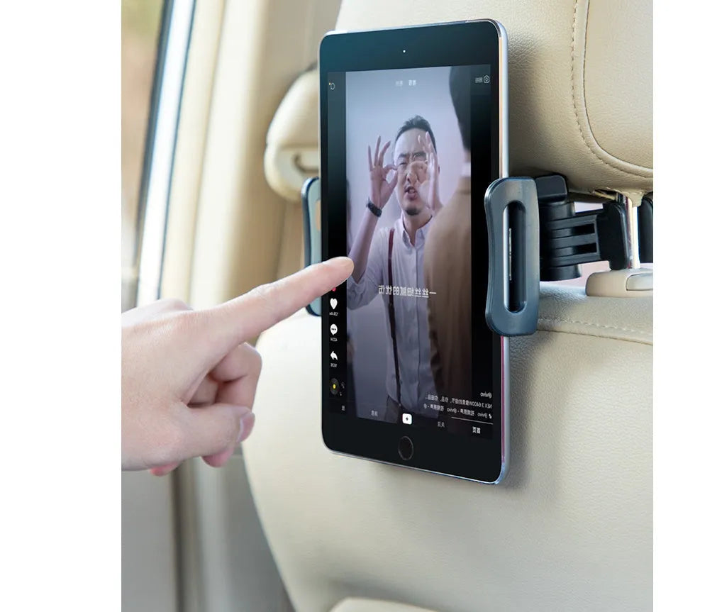 Black car phone holder mounted on vehicle rear seat base with tablet device secured in place