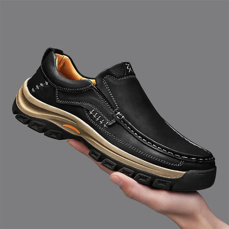 Men's black leather mountaineering shoes with thick rubber soles and round toe on a neutral background.