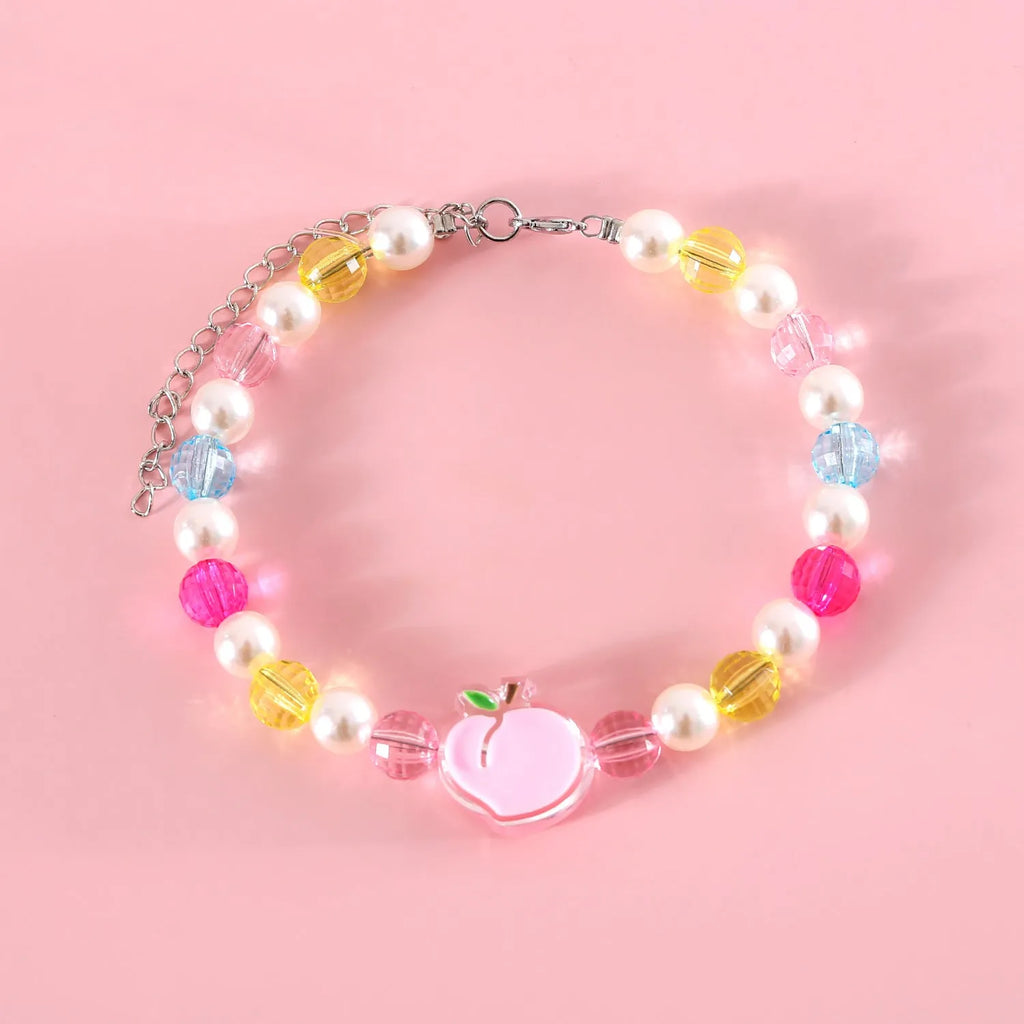 Colourful plastic pearl bead cat necklace with small flower, rainbow, or peach designs on a white background.