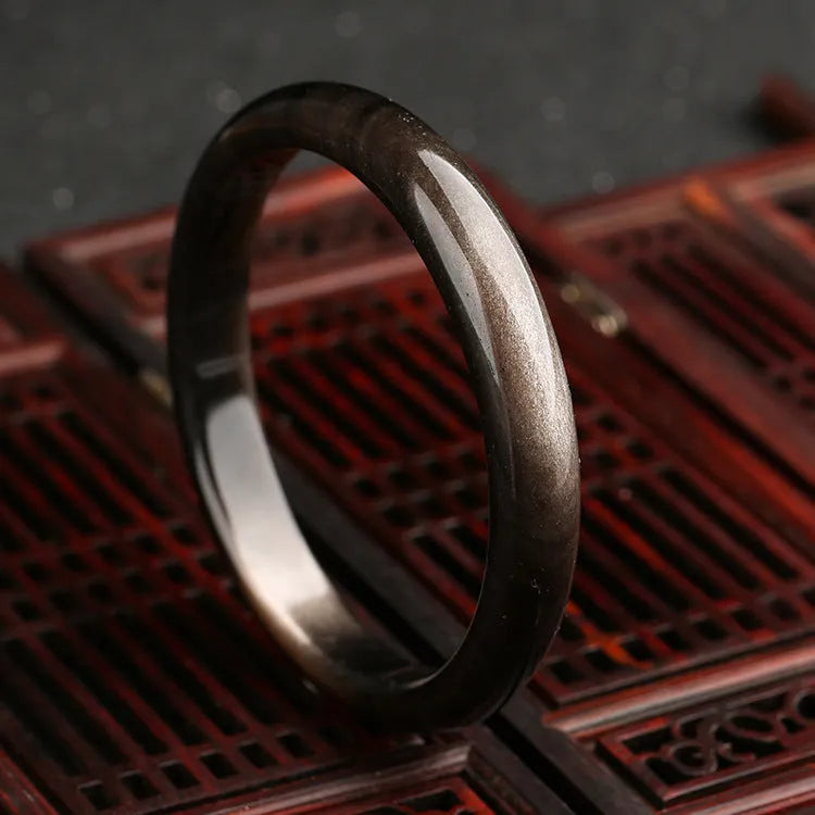 Natural silver stone cat's eye geometric bracelet in crystal and alloy on a wrist.