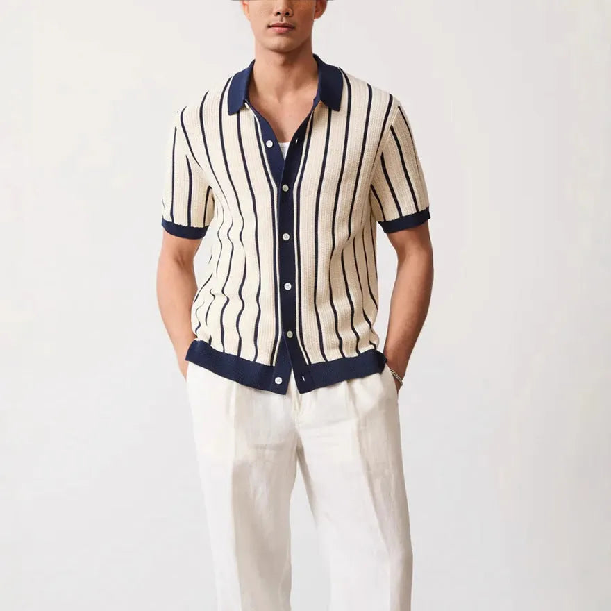 Men's white short sleeve knitted shirt with an asymmetric lapel, laid flat.