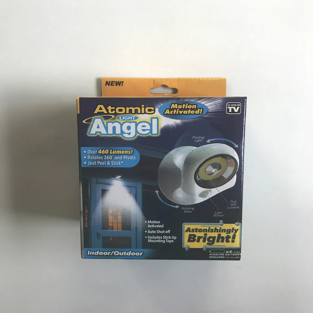 White Atomic Angel induction table lamp with compact ABS plastic body on a table.