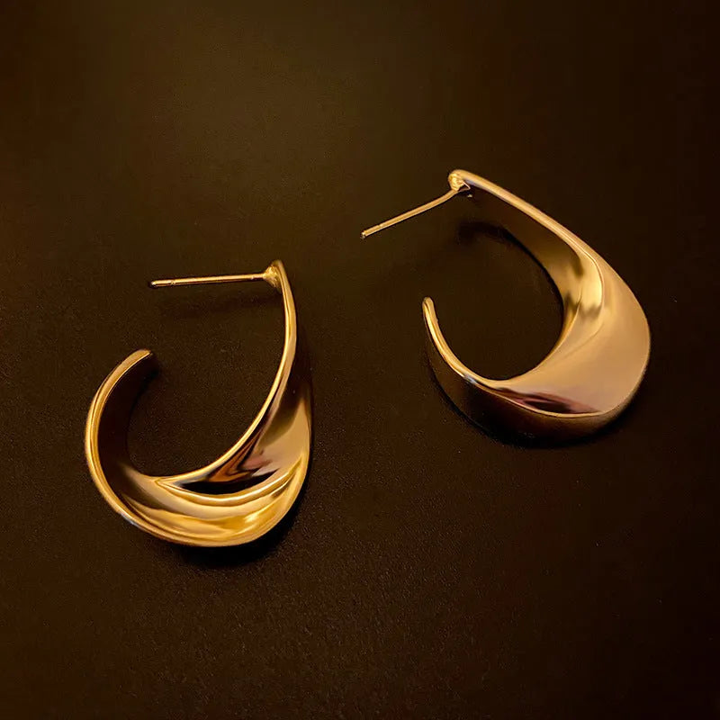 Metal twisted geometry earrings with round element in gold or silver electroplated finish
