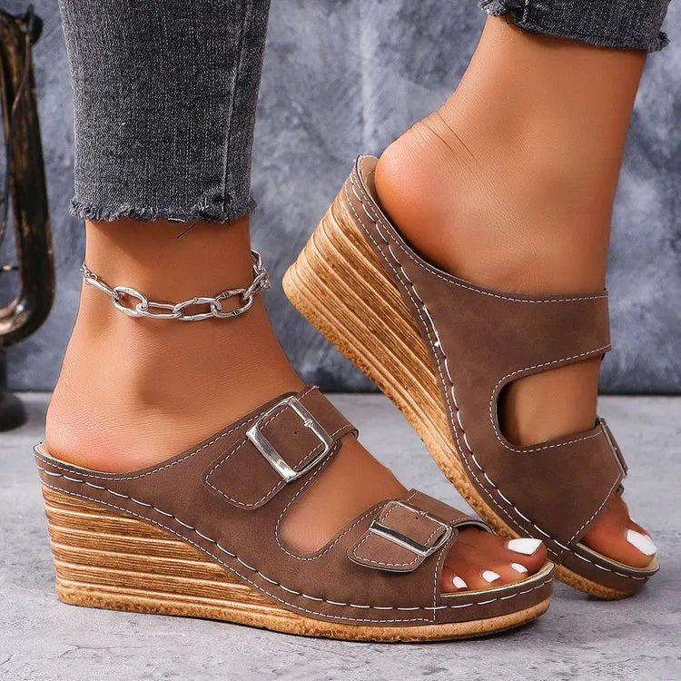 Women's creamy-white beach slippers with an outer wedge belt buckle on a flat rubber sole.