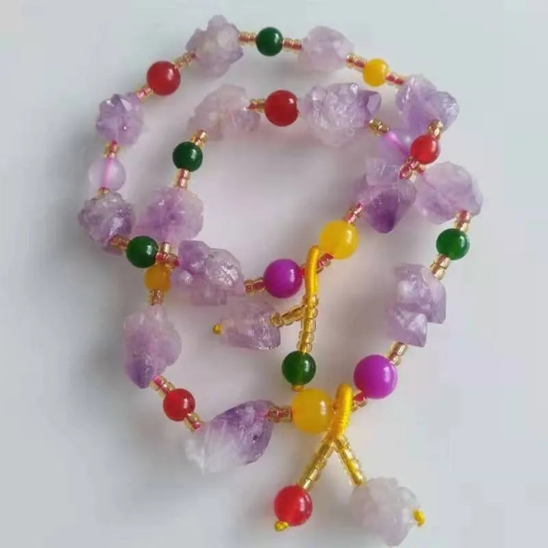 Women's amethyst bracelet with natural shaped beads and a fu character charm on an adjustable band.