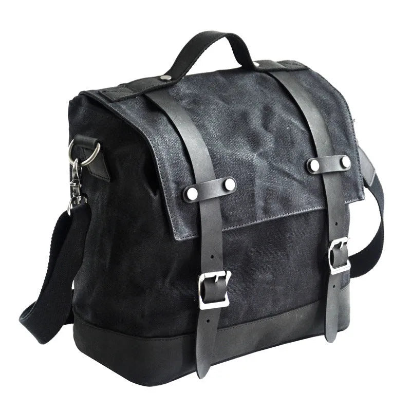 Black waterproof canvas motorcycle side pannier bag with cowhide accents showing mounting straps
