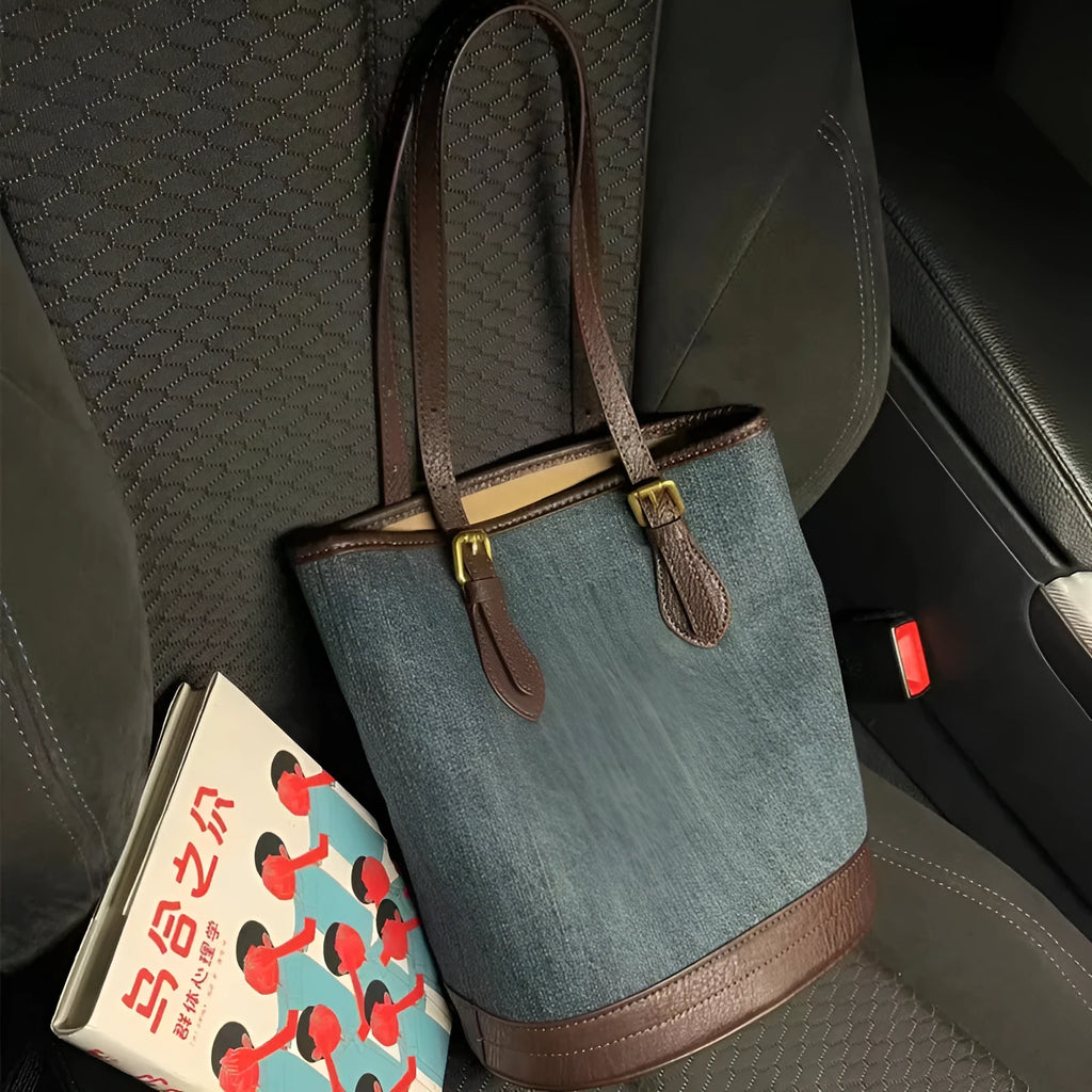Large denim patchwork bucket handbag showing adjustable strap and retro styling