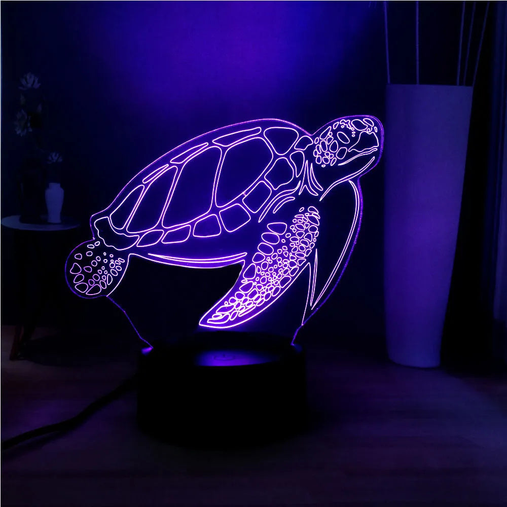 Clear acrylic 3D turtle-shaped LED night light showing multiple colour options on a dark surface.
