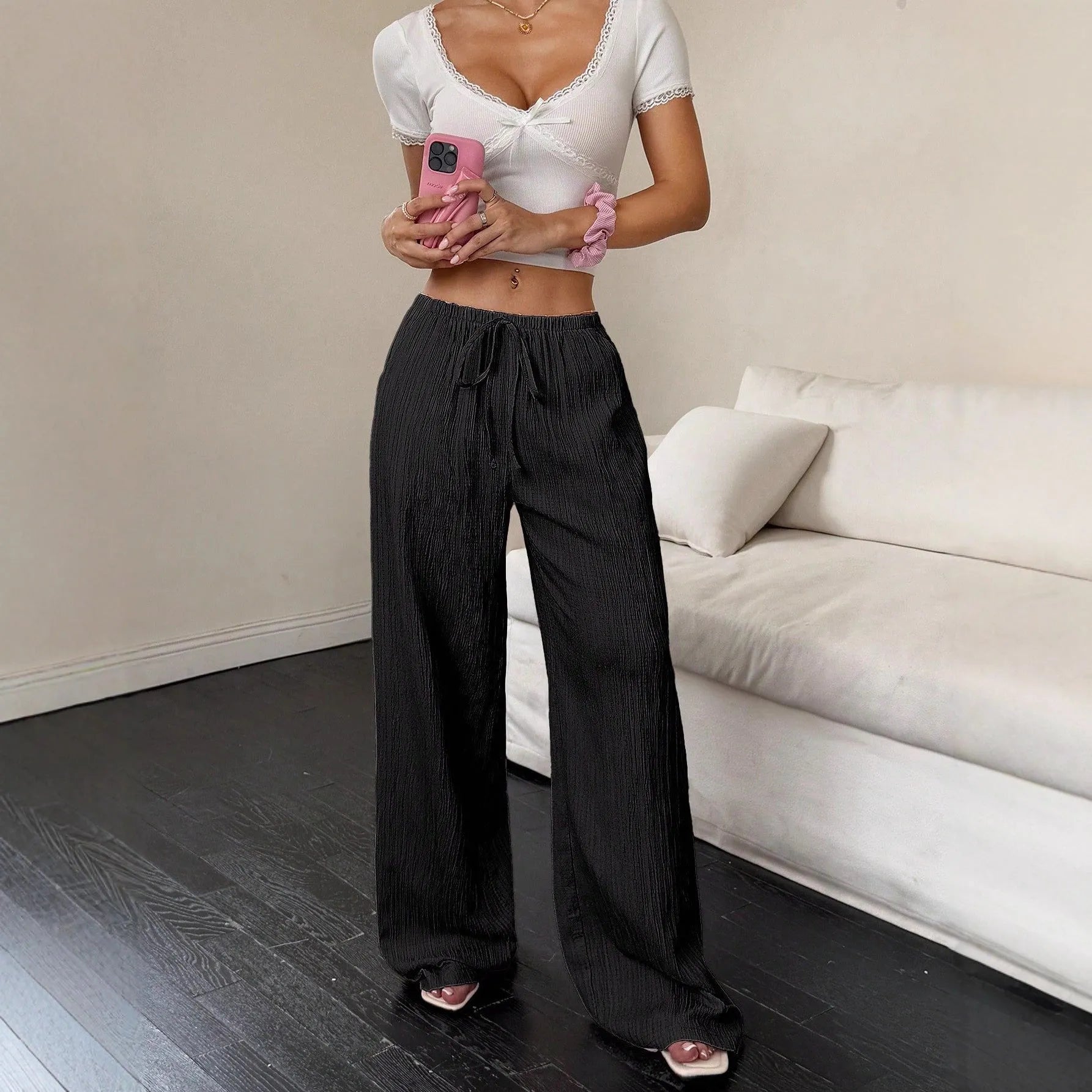 Women's black wide leg trousers with lace-up waist detail on hanger