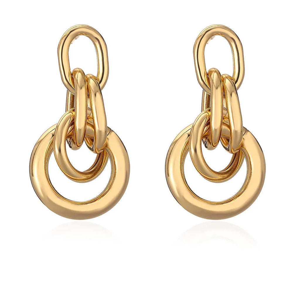 A pair of gold-toned geometric drop earrings with an irregular shape, made from copper.