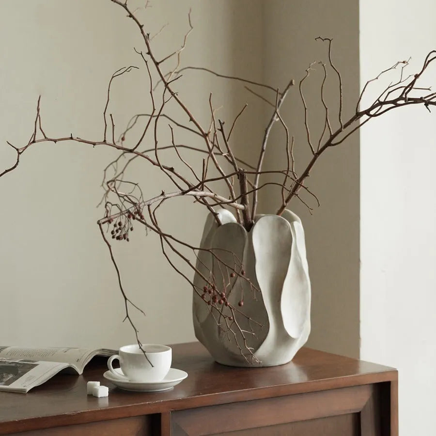 Handmade irregular ceramic vase in magnesium clay on a wooden surface.