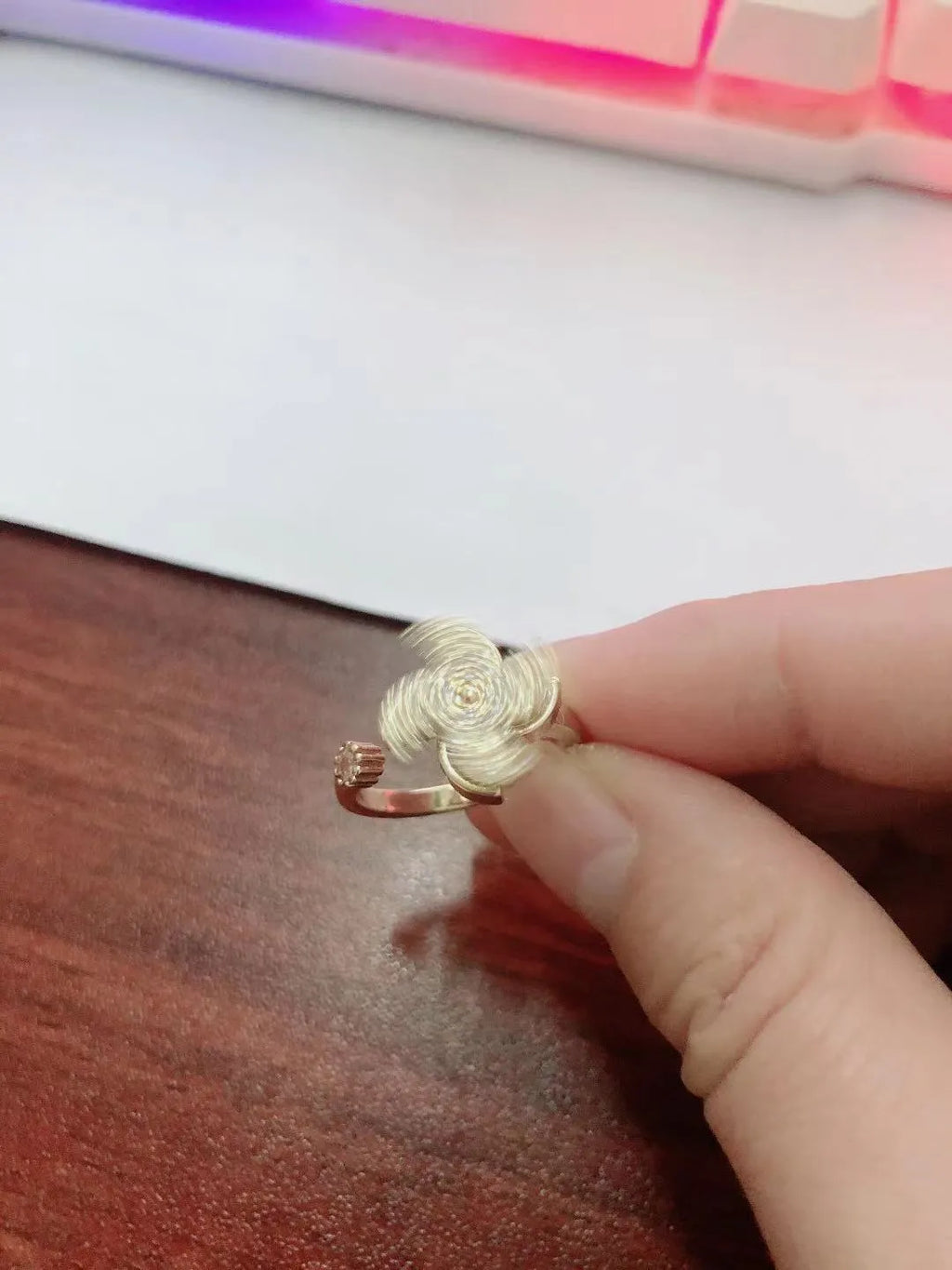 A geometric copper ring with a spinning windmill detail, shown in gold and silver electroplated finishes.